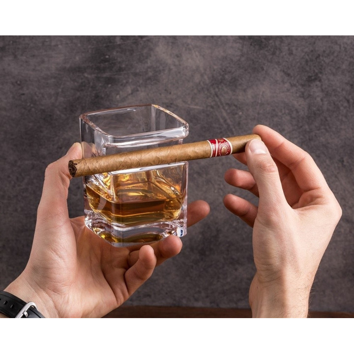 Trabuc cu whisky ținând pahar