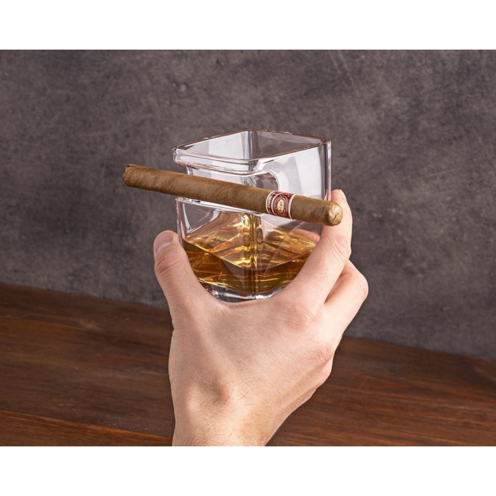 Trabuc cu whisky ținând pahar